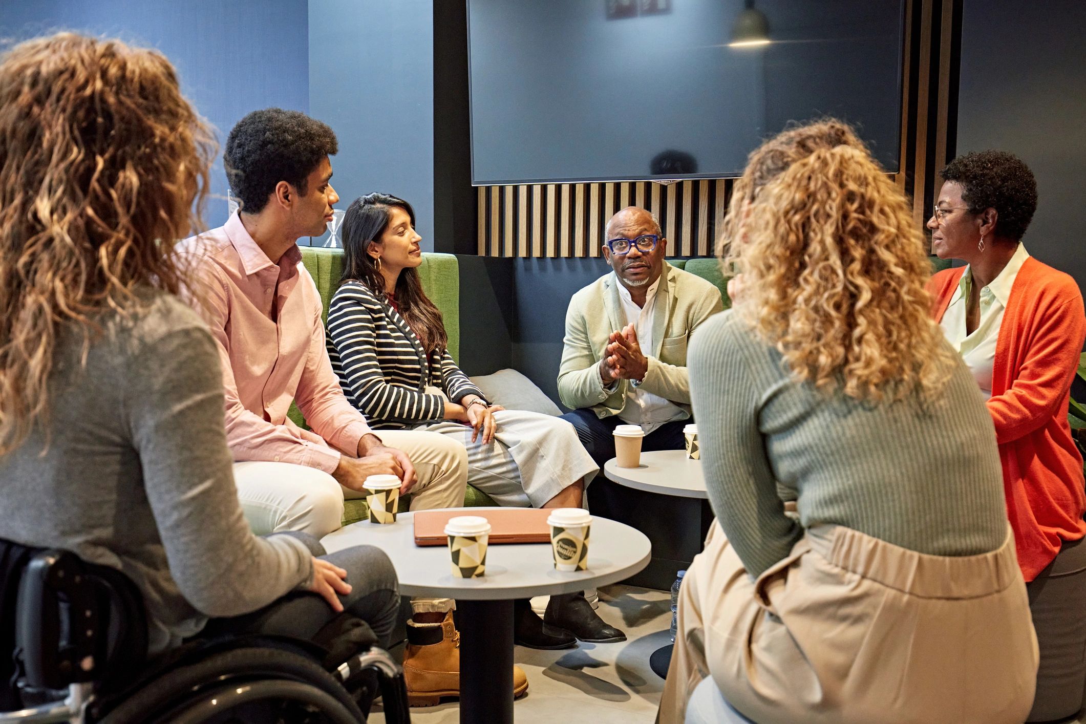 Advisor meeting with diverse clients in a modern office