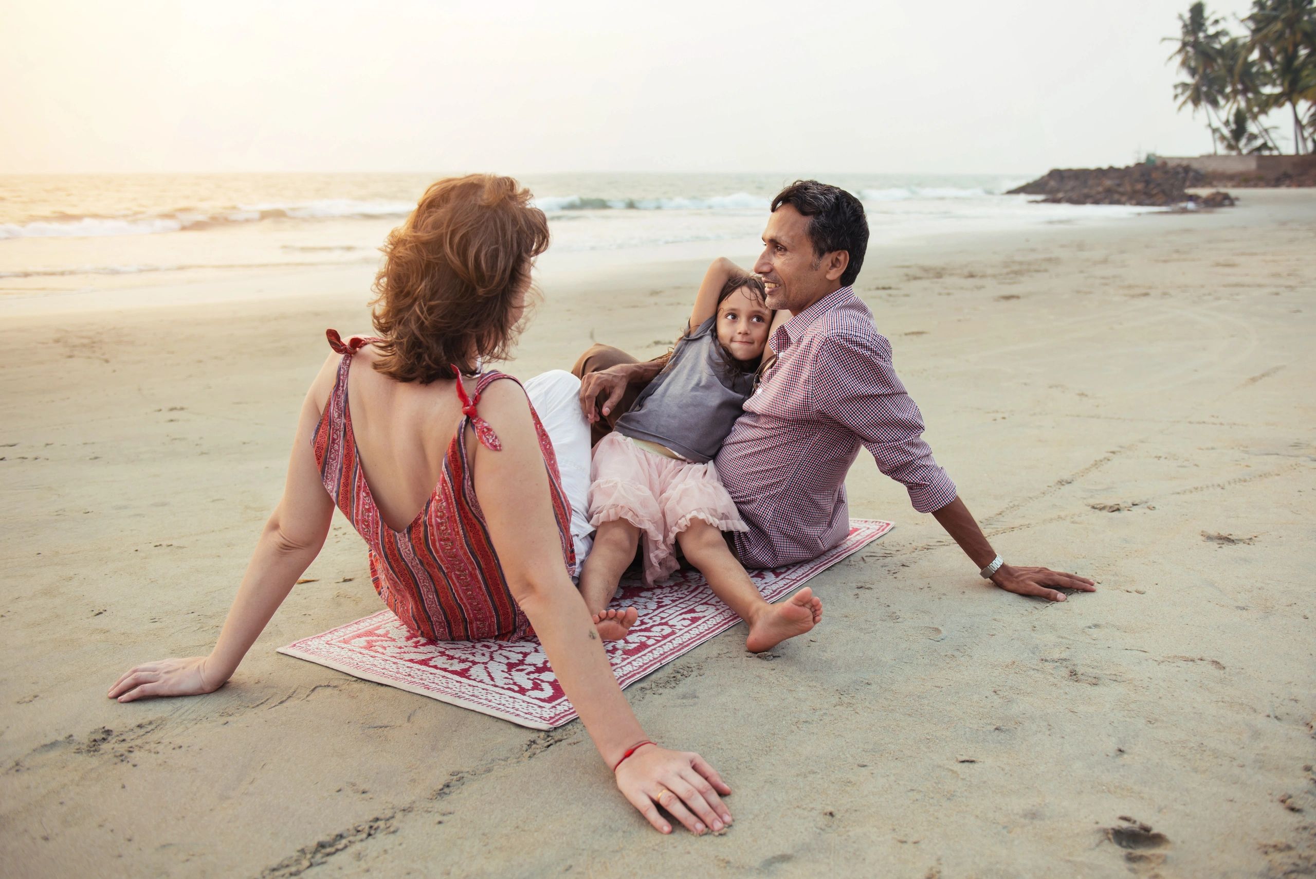 Family walking together on a beach at sunset